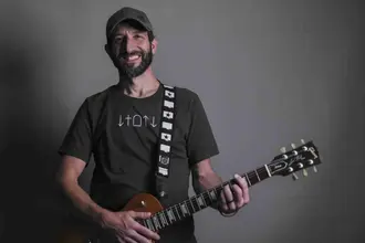 Jon Pacella holding his guitar